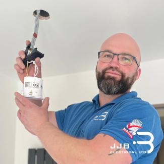 Jamie, electrician at JJB Electrical in Harlow installing a downlight. Blog Title: What Spotlights for a Kitchen?