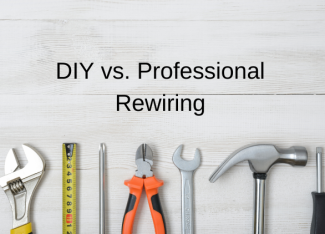 A row of tools on a pale grey background underneath the title DIY vs. Professional Rewiring: Making the Right Choice for Your home