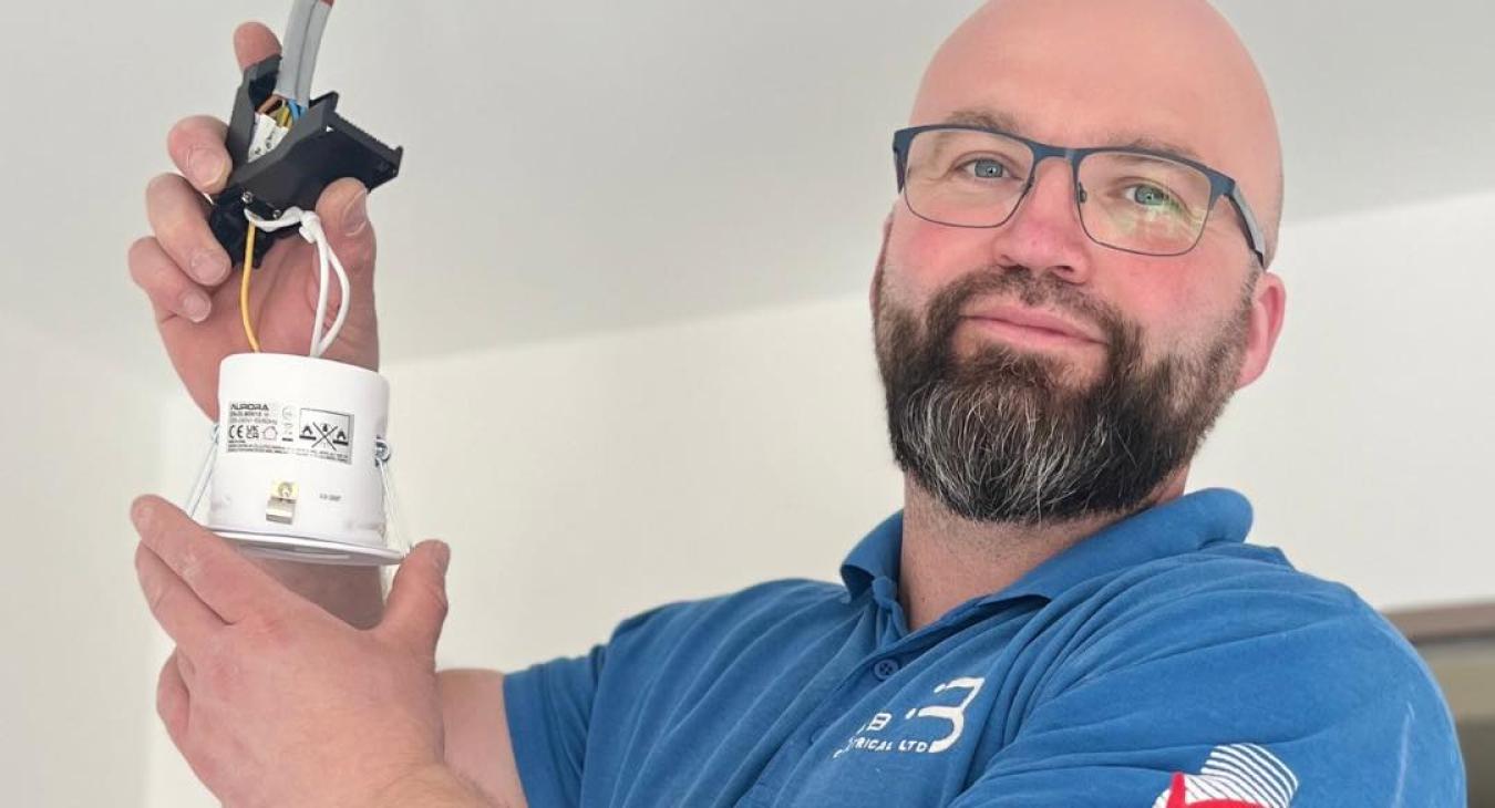 Jamie, electrician at JJB Electrical in Harlow installing a downlight. Blog Title: What Spotlights for a Kitchen?